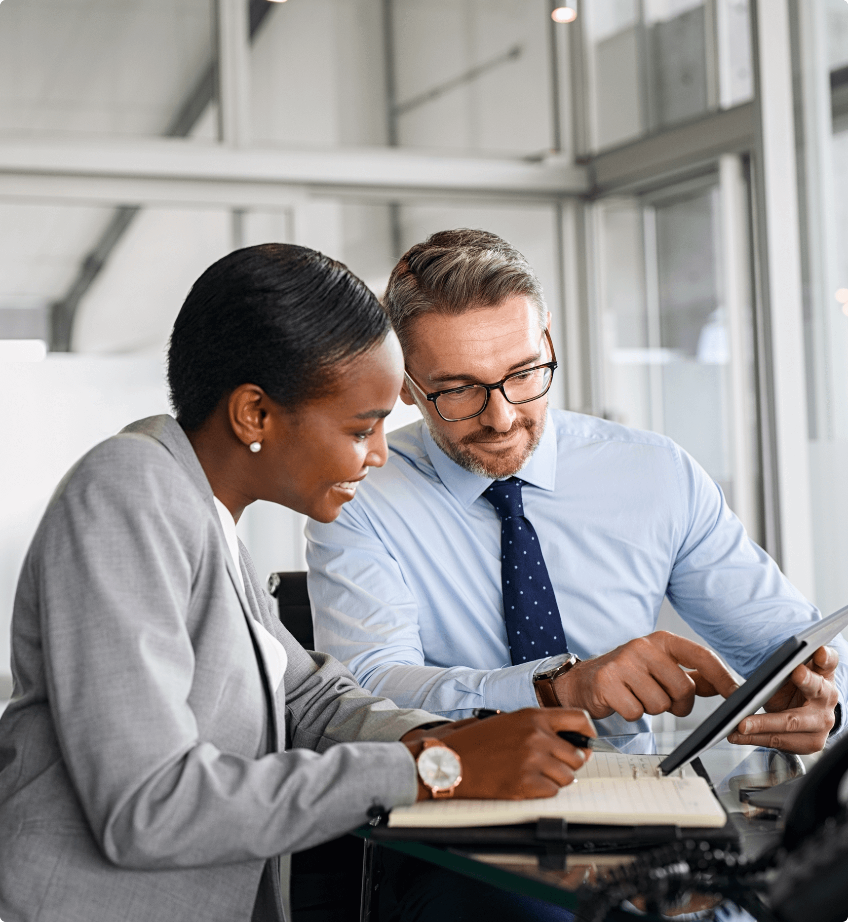 Colleagues discussing work at a desk.